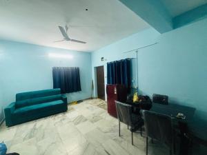 a living room with a couch and a table and chairs at Lara Homestay 2bhk in Secunderabad