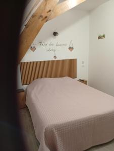 a bedroom with a white bed with a sign on the wall at Chambre familiale in Voutré