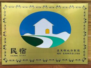 a sign for a home stay with a picture of a house at 蘭姐的民宿 in Taitung City