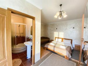 a bedroom with a bed and a bathroom with a sink at Котедж в горах у Антоніни in Solochyn