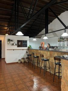 a kitchen with a counter and stools in a room at Aldeana Rural in El Cubillo