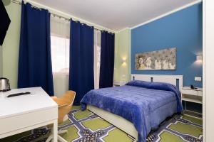 a bedroom with blue walls and a bed and a desk at villa oltremare resort in Bagheria +36 photos