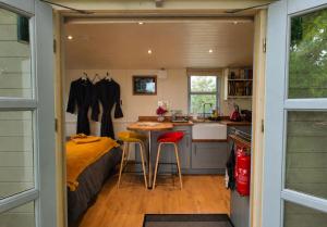 a tiny house with a kitchen and a bed at The Pheasant in Great Ellingham