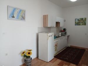 a kitchen with a white refrigerator and a vase of flowers at Apartments Smokva in Opatija