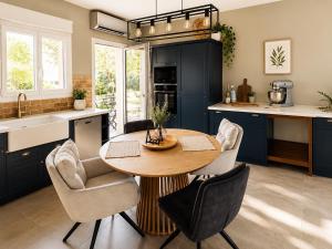 a kitchen with blue cabinets and a wooden table and chairs at Villa ATLAS relax in Prinos
