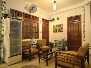 a living room with chairs and tables and a refrigerator at Seven Minutes Ella by SANS in Ella
