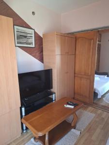 a living room with a coffee table and a tv at Apartmani Lazić No 4 in Gracanica