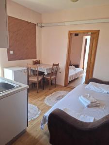 a room with a bed and a kitchen with a table at Apartmani Lazić No 4 in Gracanica