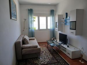 a living room with a couch and a glass table at Apartments Smokva in Opatija