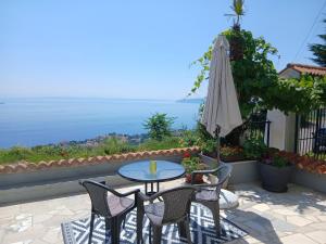 a patio with a table and chairs and an umbrella at Apartments Smokva in Opatija