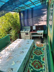 an outdoor room with a bed and a desk at Сакура in Cholpon-Ata