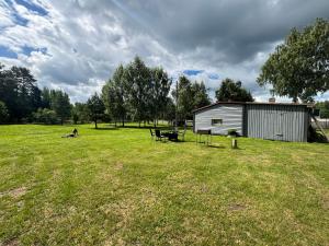 a large field with a shed and a picnic table at Cozy cabin near Peipsi in Raja