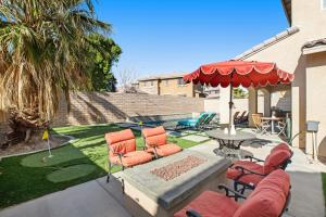 a patio with a table with chairs and an umbrella at Casa Whimsy in Indio
