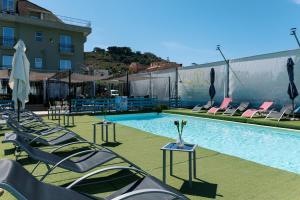 a swimming pool with lounge chairs and a building at villa oltremare resort in Bagheria