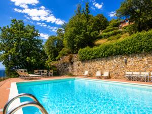 a swimming pool in front of a stone wall at Riviera Panorama Retreat in Alassio