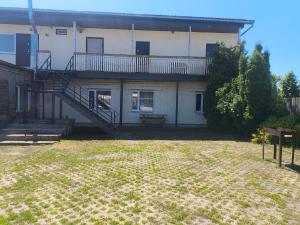 a house with a staircase in front of a yard at Vieta tavai atputai ar grilu in Liepāja