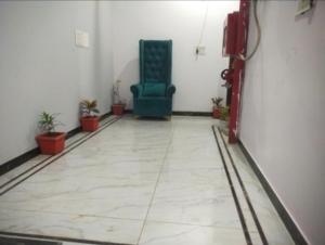 a room with a blue chair in a room with plants at Hotel River View in Ghaziabad