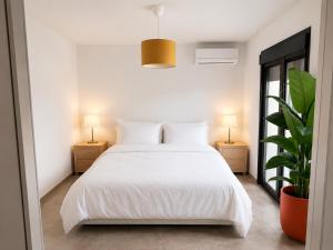 a white bedroom with a white bed and two lamps at Villa ATLAS relax in Prinos