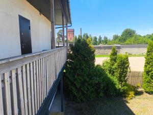 a balcony of a building with a door and bushes at Vieta tavai atputai ar grilu in Liepāja