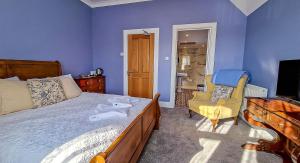 a bedroom with a bed and a chair and a television at Tower Hotel in Oxton