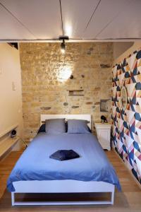 a bedroom with a large bed in a brick wall at Chez Mathilde et Kévin in Saint-Maurice
