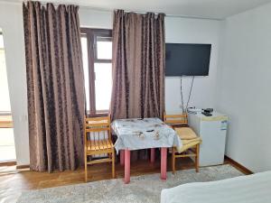 a room with a table and a window with a television at Сакура in Cholpon-Ata