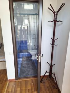 a bathroom with a toilet and a cross on the wall at Сакура in Cholpon-Ata +26 photos