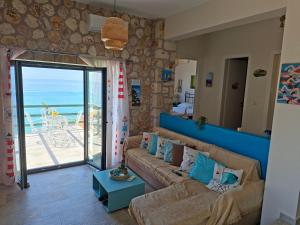 a living room with a couch and a view of the ocean at Korina's house in Loutsa