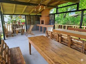 an outdoor patio with wooden benches and a fireplace at Maia's Guesthouse in Chvabiani