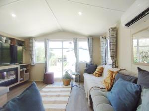 a living room with a couch and a tv at The Hillside Lodge in Pizarra