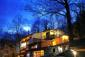 un edificio con luci accese di fronte ad un albero di Casa Rural El Reixac a Sant Joan de les Abadesses