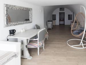 a white dining room with a white table and chairs at Diamond on the cliff Hotel&Suites Imerovigli in Imerovigli