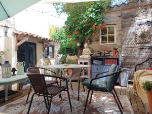 a patio with a table and chairs and a kitchen at Le toit du monde in Ceyreste