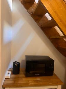 a microwave sitting on a wooden shelf under a staircase at Princeps De Cura Traditional in Symi