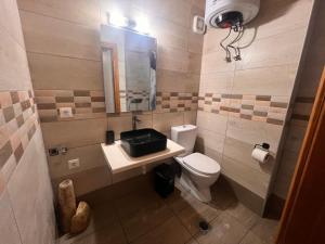 a bathroom with a toilet and a sink and a mirror at Princeps De Cura Traditional in Symi