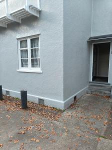 a gray building with a window and a door at Larsen Apartment in Palmerston North