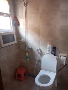 a bathroom with a shower with a toilet and a window at Home Room in Ghukra