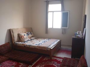 a small bedroom with a bed and a window at Home Room in Ghukra