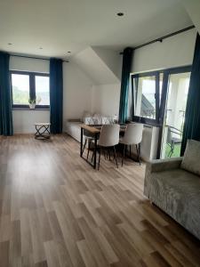 a living room with a table and a couch at Biała Ostoja 517-539-965 in Berezka