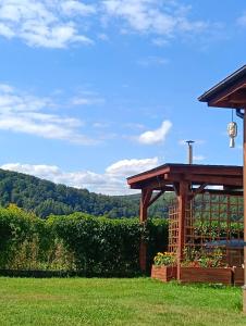 a wooden gazebo in a yard with a hill at Pensjonat na Wzgórzu in Solina