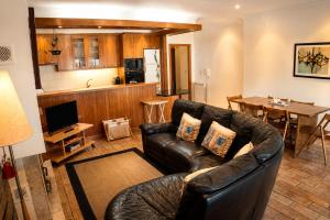 a living room with a leather couch and a kitchen at Casa da Cuca in Fão +16 photos