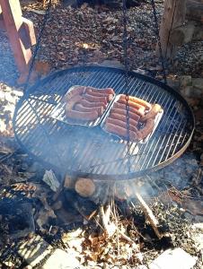 two hot dogs are cooking on a grill at Pensjonat na Wzgórzu in Solina