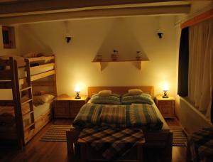 a bedroom with two bunk beds and two lamps at Mura Vendégház in Murakeresztúr