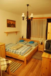 a bedroom with two beds and a television at Mura Vendégház in Murakeresztúr