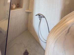 a shower with a shower head in a bathroom at Diamond on the cliff Hotel&Suites Imerovigli in Imerovigli +53 photos