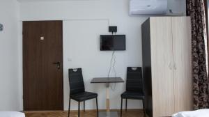 a room with a table and two chairs and a tv at Guest Rooms Old Captain in Burgas