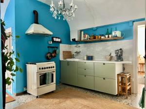 a kitchen with blue walls and a white stove top oven at Historic Center Cottage Style Apartment in Pontremoli