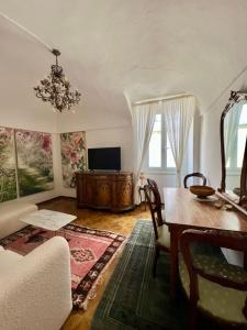 a living room with a dining room table and a chandelier at Historic Center Cottage Style Apartment in Pontremoli