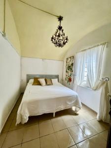 a bedroom with a white bed and a chandelier at Historic Center Cottage Style Apartment in Pontremoli