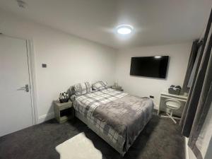 a bedroom with a bed and a flat screen tv at Silverhill in Bradford